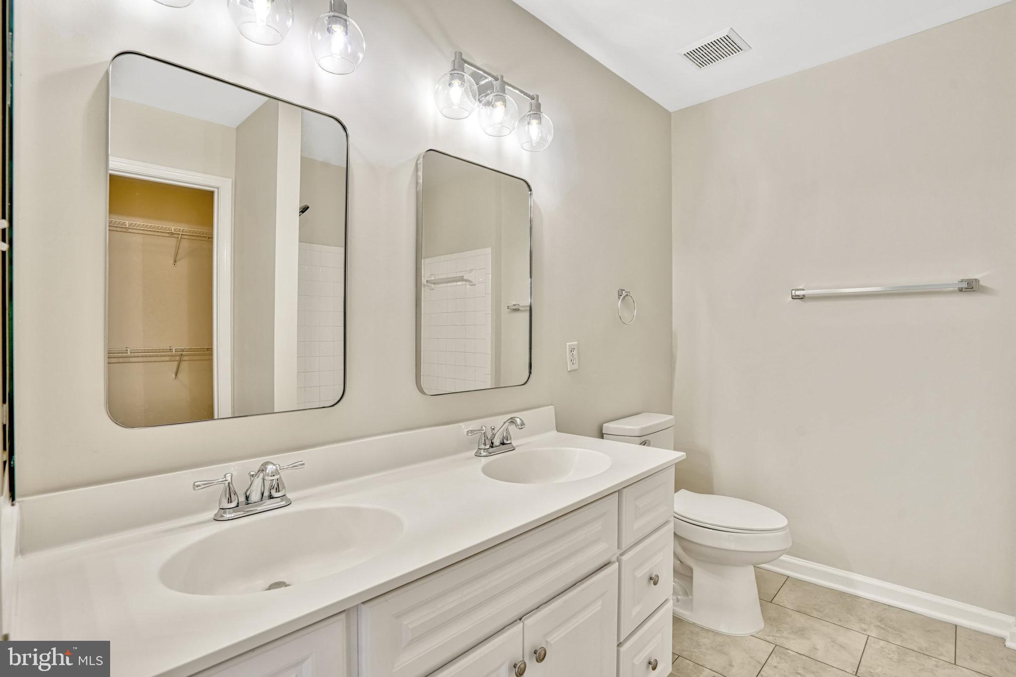 10159 Elgin Way Bristow, VA 20136 - Photo 36 of 50 a bathroom with a double vanity sink mirror and toilet