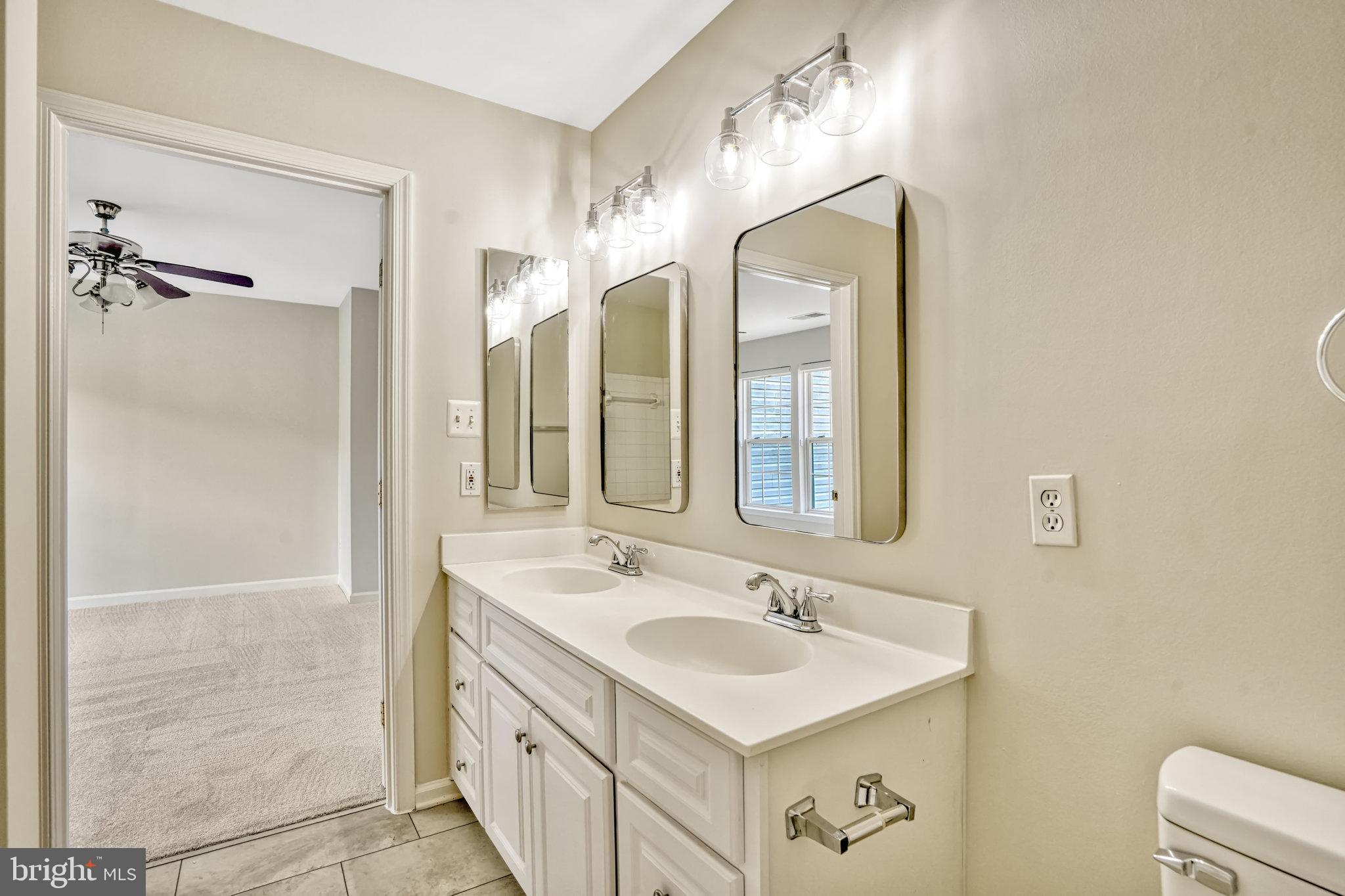 10159 Elgin Way Bristow, VA 20136 - Photo 38 of 50 a bathroom with a sink a mirror a vanity and a shower
