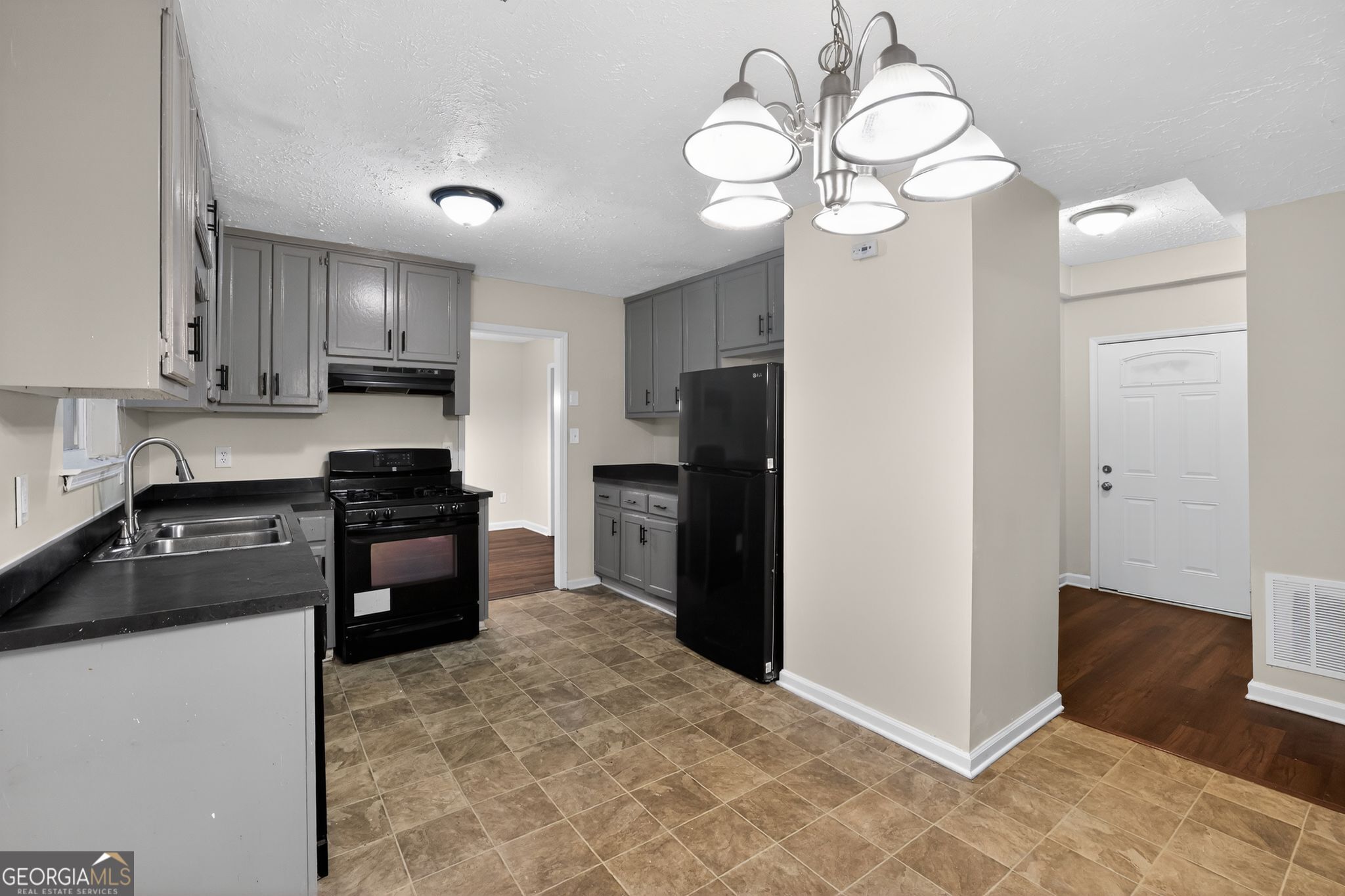 4586 High Gate Lane Lithonia, GA 30038 - Photo 13 of 33 a kitchen with kitchen island granite countertop stainless steel appliances cabinets a sink and a counter top space