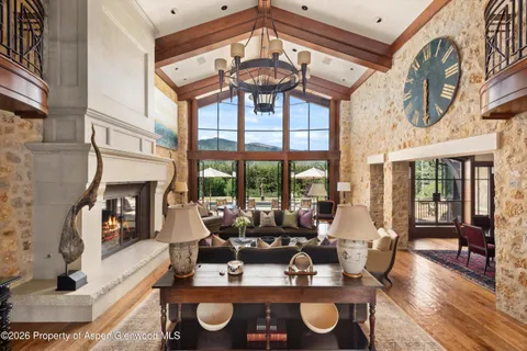 a living room with fireplace furniture and a large window