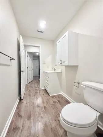 a white toilet sitting next to a bathroom sink and a mirror