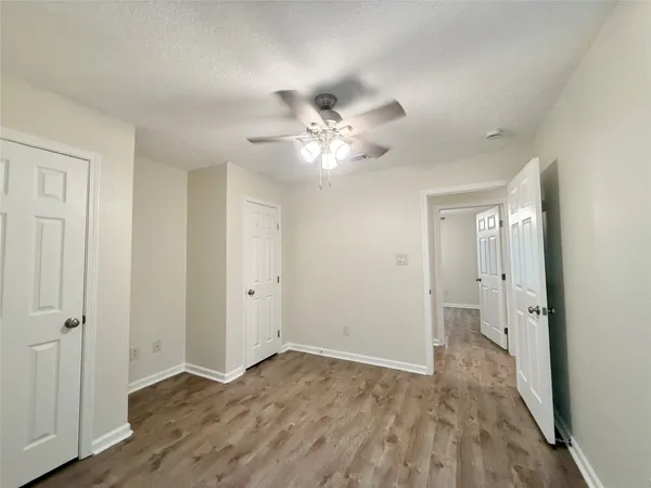 a view of an empty room with closet and a chandelier fan