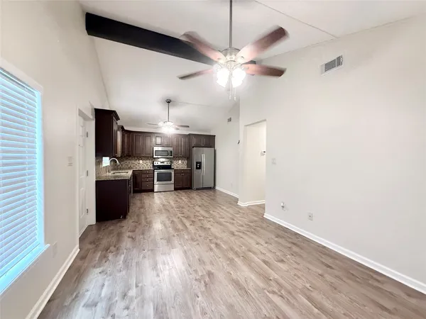 a view of a kitchen with wooden floor and a window