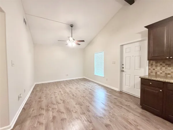a view of a kitchen with a sink and dishwasher with wooden floor