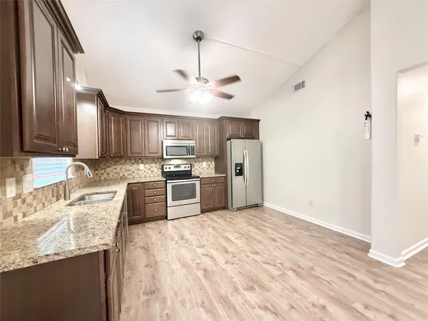 a kitchen with granite countertop a center island stainless steel appliances and cabinets