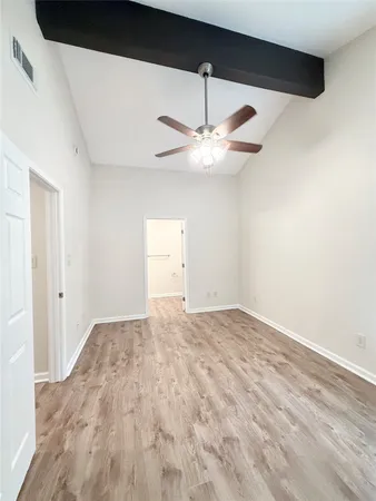 a view of an empty room with a chandelier fan