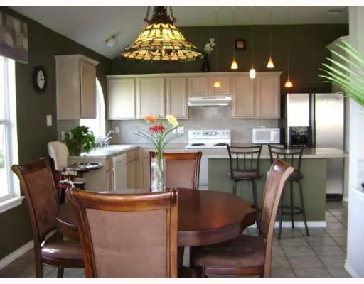 a dining room filled chandelier and kitchen view