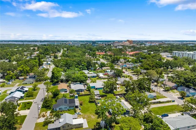 an aerial view of residential houses with outdoor space and trees