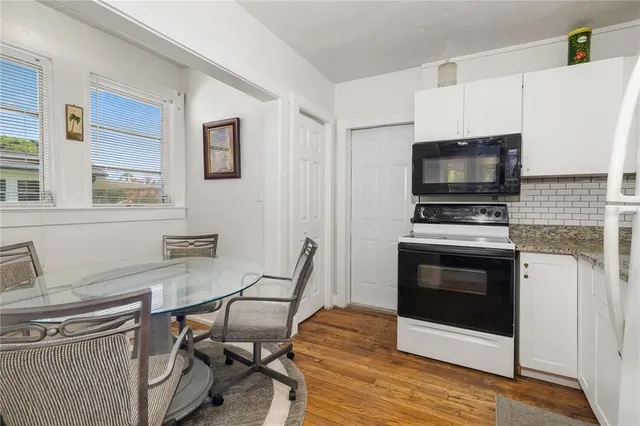 a kitchen with a stove a microwave and white cabinets