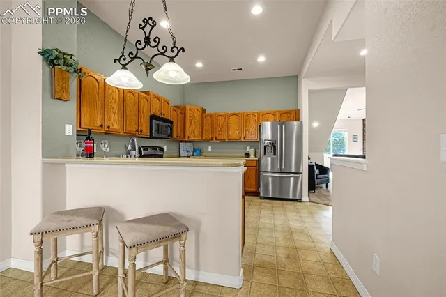 a kitchen with stainless steel appliances granite countertop a sink refrigerator and cabinets