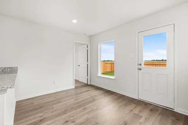 an empty room with a window and a wooden floor