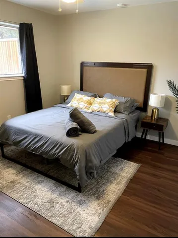 a bedroom with a bed and wooden floor