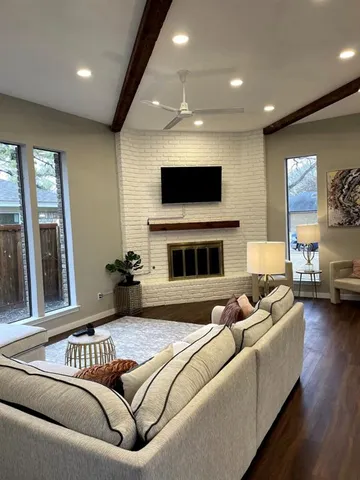 a living room with furniture a flat screen tv and a fireplace