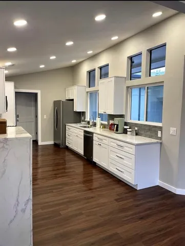 a kitchen with stainless steel appliances kitchen island granite countertop a stove and a refrigerator