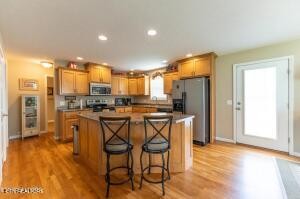 338 Pistole Road Sparta, TN 38583 - Photo 10 of 39 a kitchen with stainless steel appliances a refrigerator a stove top oven a sink dishwasher and white cabinets with wooden floor