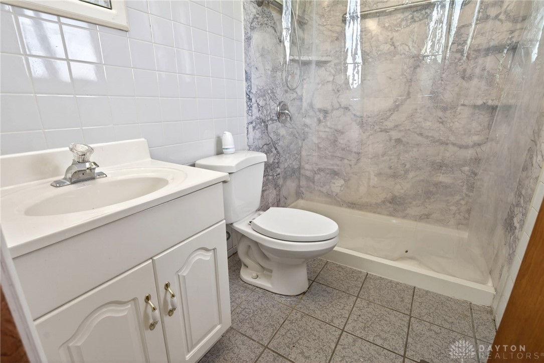 1005 Free Road New Carlisle, OH 45344 - Photo 22 of 43 This bathroom features a functional vanity with ample storage and tiled flooring.
