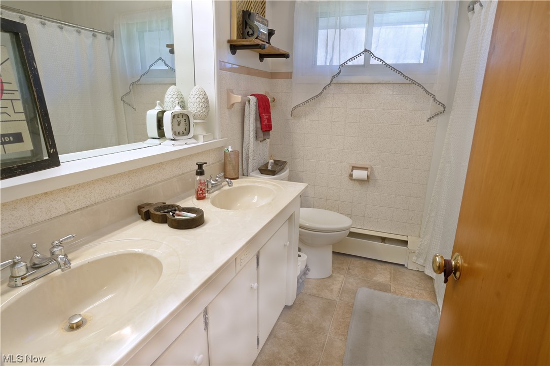 4061 Marks Rootstown, OH 44272 - Photo 13 of 25 Bathroom with tile flooring, baseboard heating, toilet, tile walls, and double sink vanity