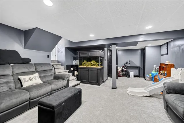 a living room with furniture and a gym machine