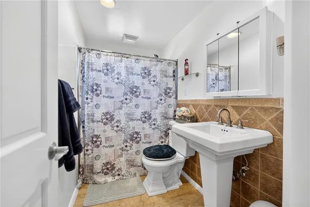 a bathroom with a sink and mirror with toilet