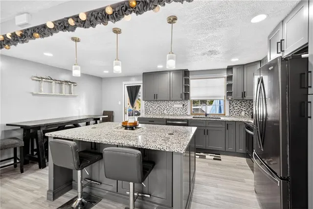 a kitchen with a table a refrigerator and cabinets