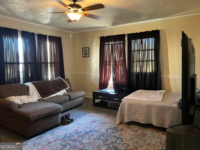 a bedroom with a bed couch and a window