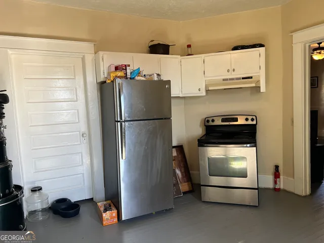 a kitchen with stainless steel appliances a refrigerator and a stove top oven