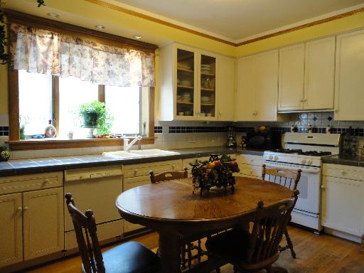 2529 Grove Avenue Berwyn, IL 60402 - Photo 4 of 16 a kitchen with a table chairs stove and cabinets