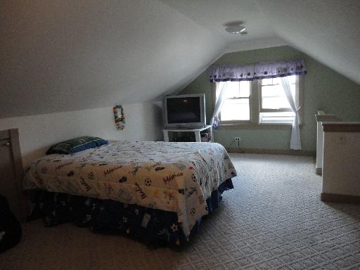 2529 Grove Avenue Berwyn, IL 60402 - Photo 9 of 16 a spacious bedroom with a bed and a flat tv screen on a dresser