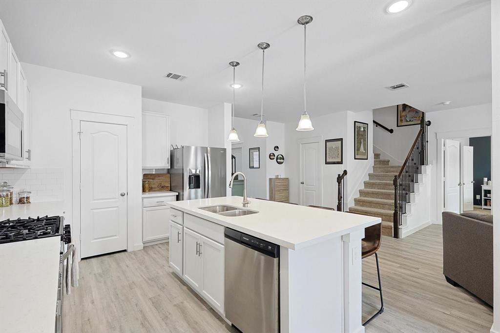 4235 Bullock Lane Forney, TX 75126 - Photo 12 of 40 a kitchen with a sink a counter top space stainless steel appliances and wooden floor