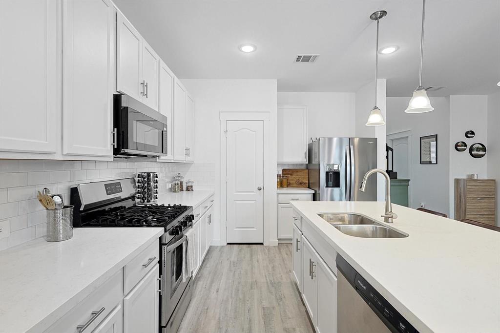 4235 Bullock Lane Forney, TX 75126 - Photo 13 of 40 a kitchen with a sink a stove and refrigerator