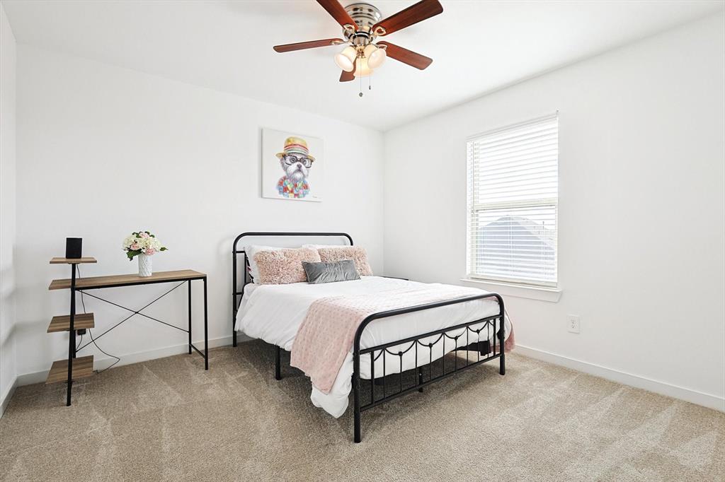 4235 Bullock Lane Forney, TX 75126 - Photo 28 of 40 a spacious bedroom with a bed and a table