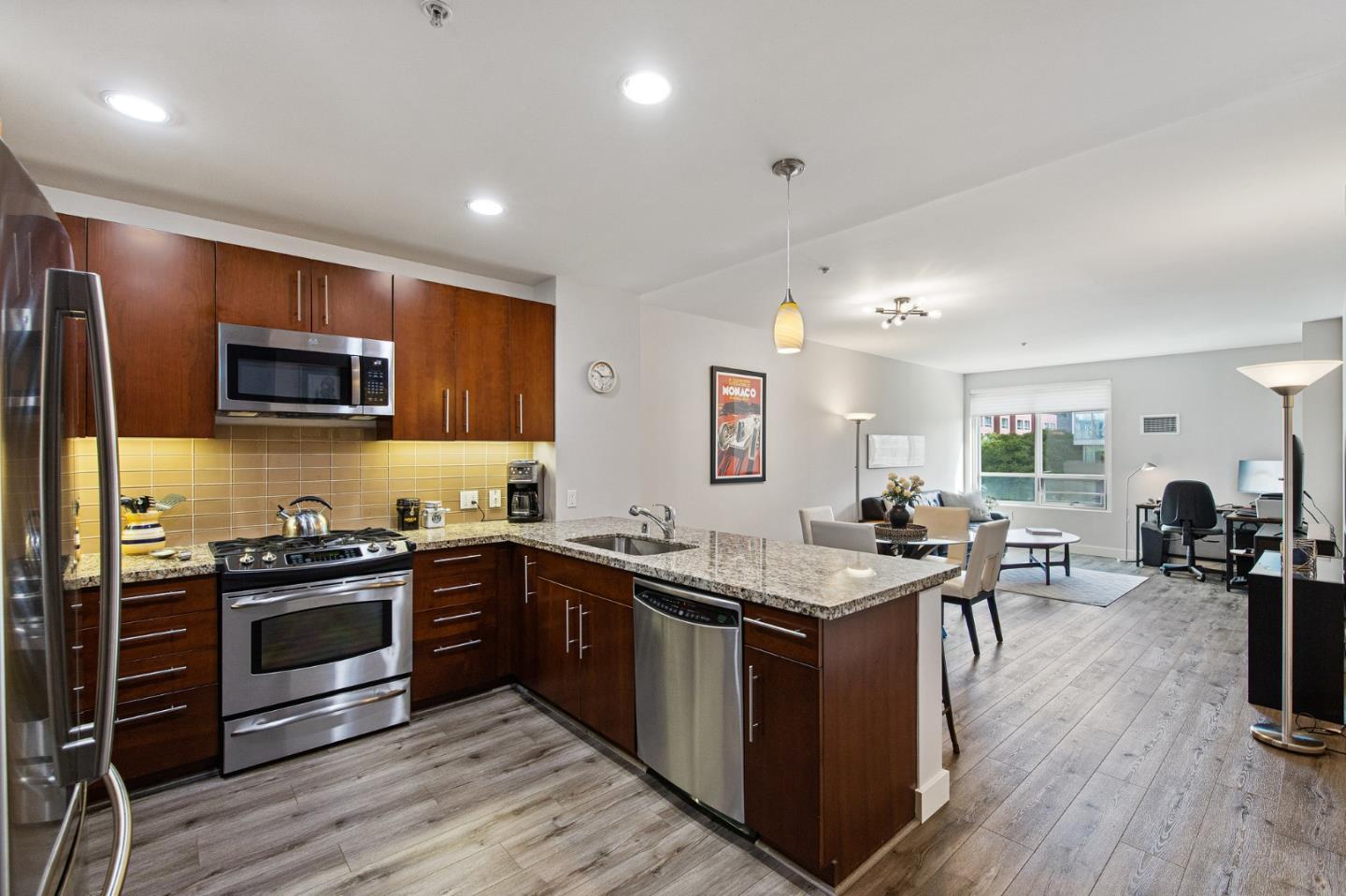 325 Berry Street, Unit 322 San Francisco, CA 94158 - Photo 1 of 17 a kitchen with stainless steel appliances granite countertop wooden cabinets a sink dishwasher a stove and a refrigerator