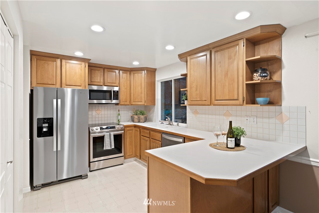 19728 45th Avenue Southeast Bothell, WA 98012 - Photo 11 of 25 a kitchen with stainless steel appliances a sink stove refrigerator and cabinets