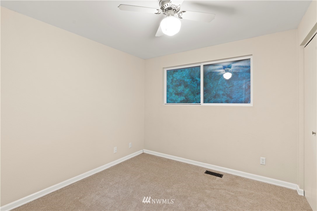 19728 45th Avenue Southeast Bothell, WA 98012 - Photo 13 of 25 an empty room with a chandelier fan and windows