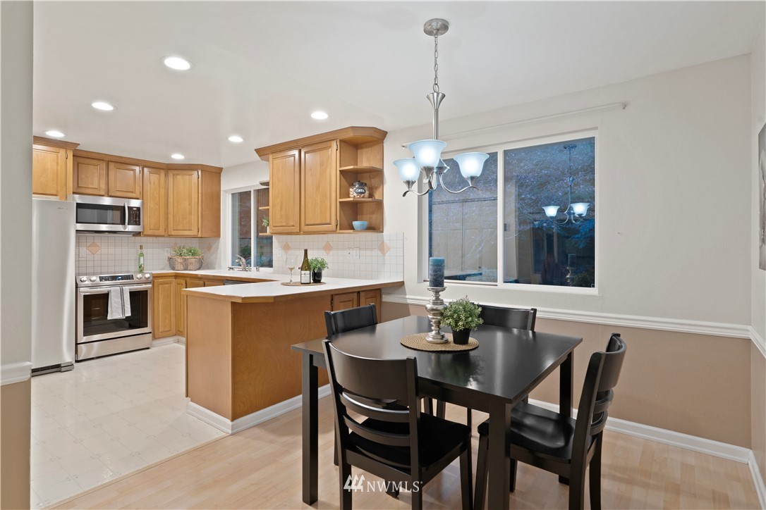 19728 45th Avenue Southeast Bothell, WA 98012 - Photo 10 of 25 a kitchen with a dining table chairs stainless steel appliances and cabinets