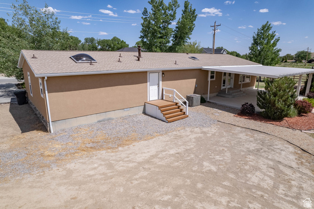1407 North 1250th Street West Helper, UT 84526 - Photo 3 of 27 Rear view of house featuring a shingled roof and stucco siding