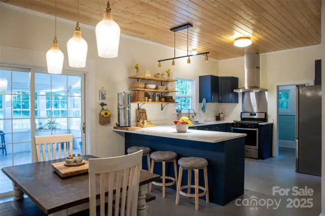 a kitchen with kitchen island a dining table and chairs