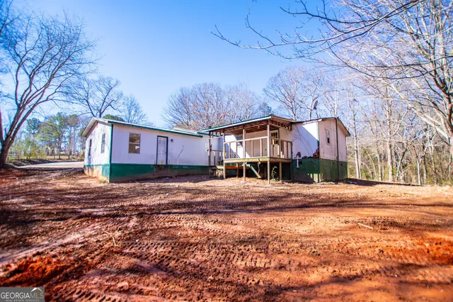 a backyard of a house with a yard and large trees