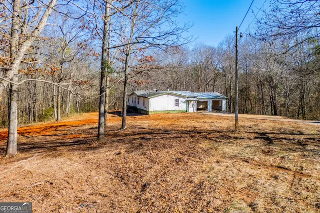 a view of a house with backyard and trees
