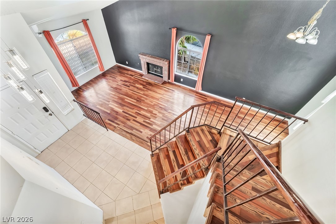 1402 Rim Fire Circle Henderson, NV 89014 - Photo 20 of 48 Rich wood floors and a brick fireplace anchor this expansive, high-ceilinged living space.
