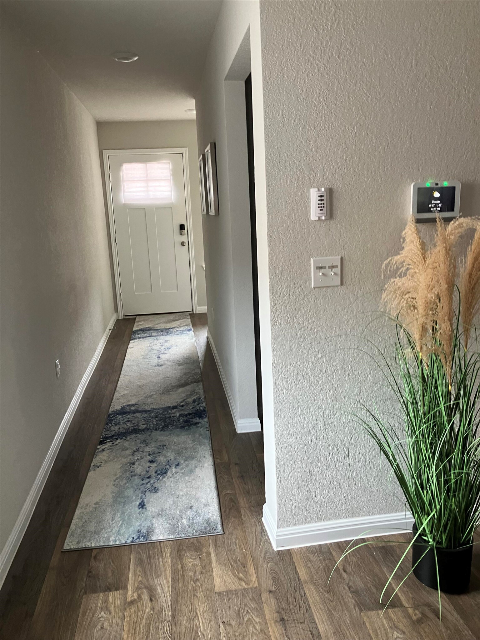 119 Mercer Street Bastrop, TX 78602 - Photo 4 of 19 Hallway featuring a textured wall and dark wood-style floors