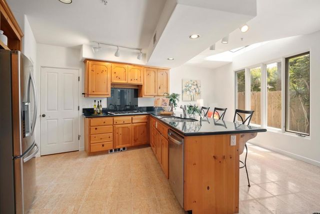 a kitchen with granite countertop a sink stove and cabinets