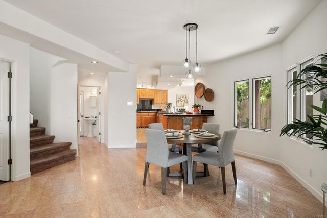 a view of a dining room and livingroom with furniture wooden floor a chandelier