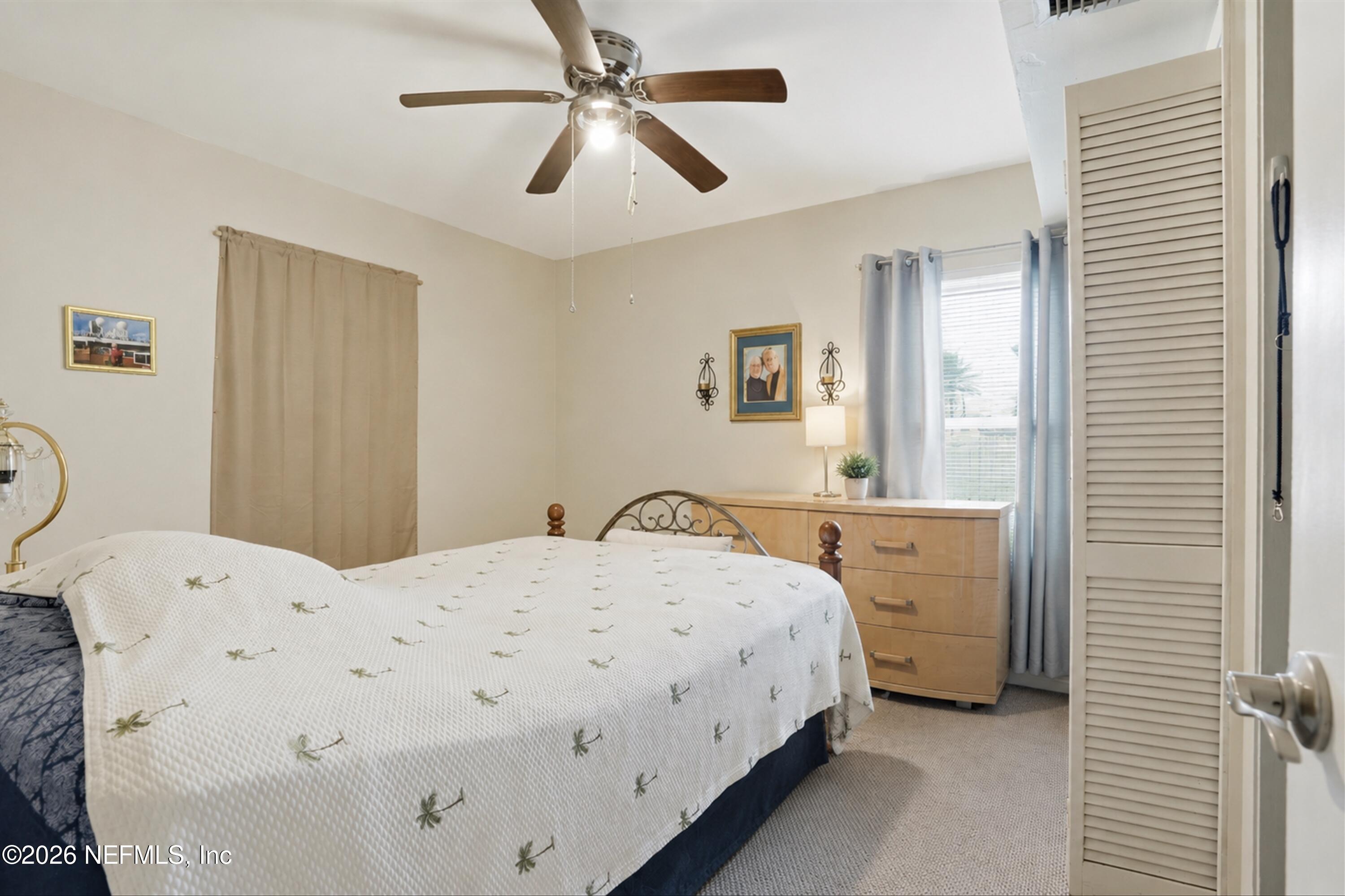 124 Hopkins Street Neptune Beach, FL 32266 - Photo 25 of 44 a bedroom with a bed and a chandelier