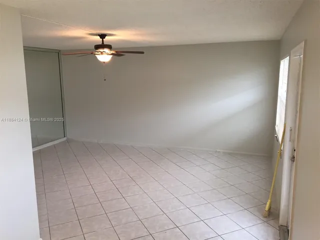 an empty room with chandelier fan
