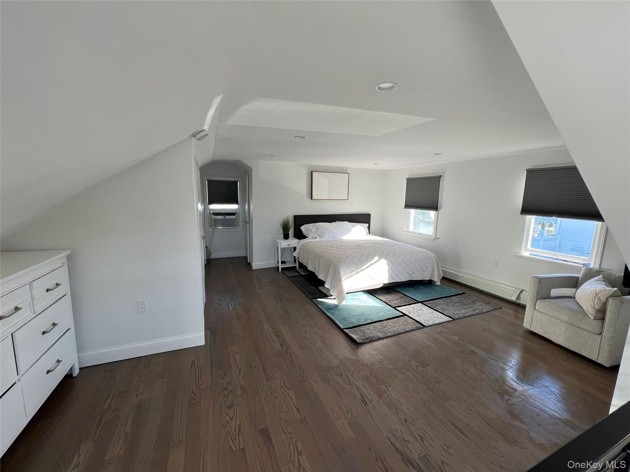 100 Clubhouse Road Bellmore, NY 11710 - Photo 16 of 18 Bedroom featuring dark wood finished floors and a baseboard radiator