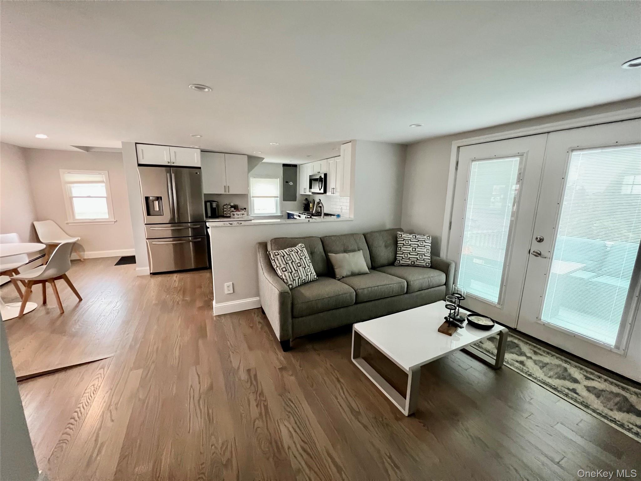 100 Clubhouse Road Bellmore, NY 11710 - Photo 10 of 18 Living room with light wood-type flooring, french doors, and recessed lighting