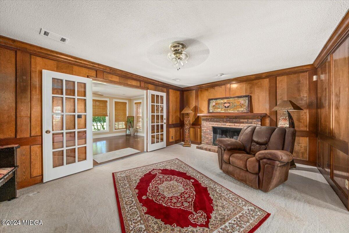 5369 Rivoli Drive Macon, GA 31210 - Photo 17 of 40 a living room with furniture a flat screen tv and a floor to ceiling window