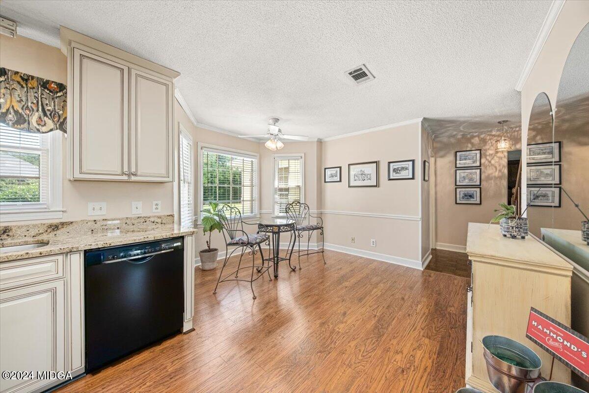 5369 Rivoli Drive Macon, GA 31210 - Photo 23 of 40 a kitchen with granite countertop a stove top oven a sink a dining table and chairs with wooden floor