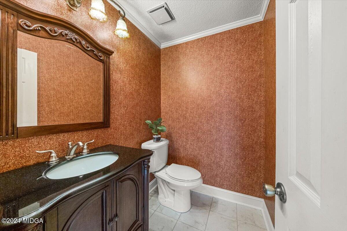 5369 Rivoli Drive Macon, GA 31210 - Photo 27 of 40 a bathroom with a granite countertop sink toilet and a mirror